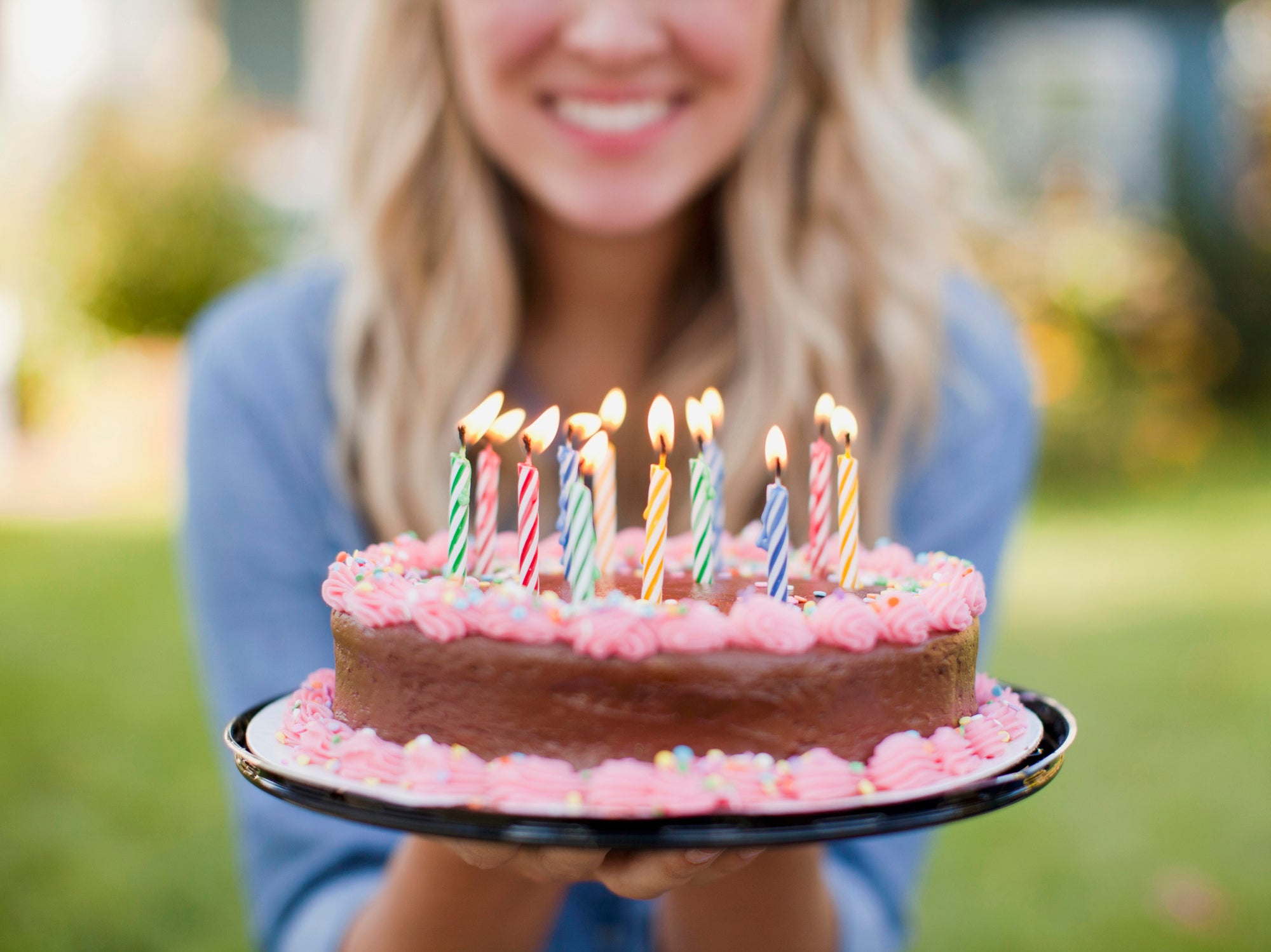 USA, Utah, Provo, Mid-section of young woman holding birthday cake