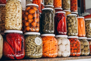 Closeup of canned vegetables in glass jars on the table in the market. Homemade vegetables preserves.
