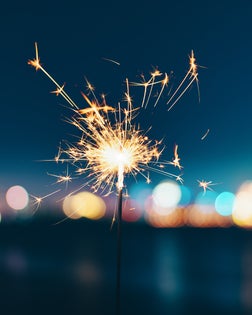 Burning sparkler against sky