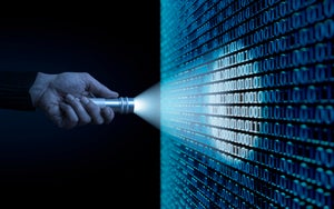 Man aiming flashlight at binary code