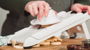 Slicing organic gold potatoes on a V-blade mandoline