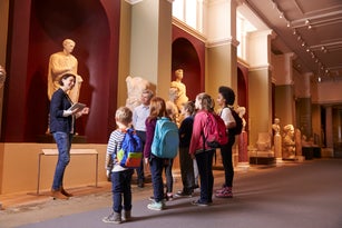 Pupils And Teacher On School Field Trip To Museum