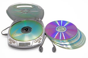 Close-up of a discman with a stack of cd's next to it isolated on white background