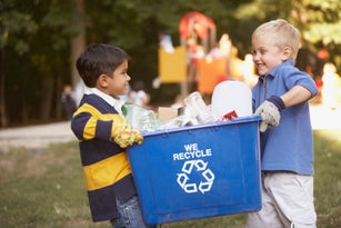 Two boys carrying recycling container