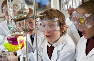 Group of children (9-12) watching experiment in school laboratory