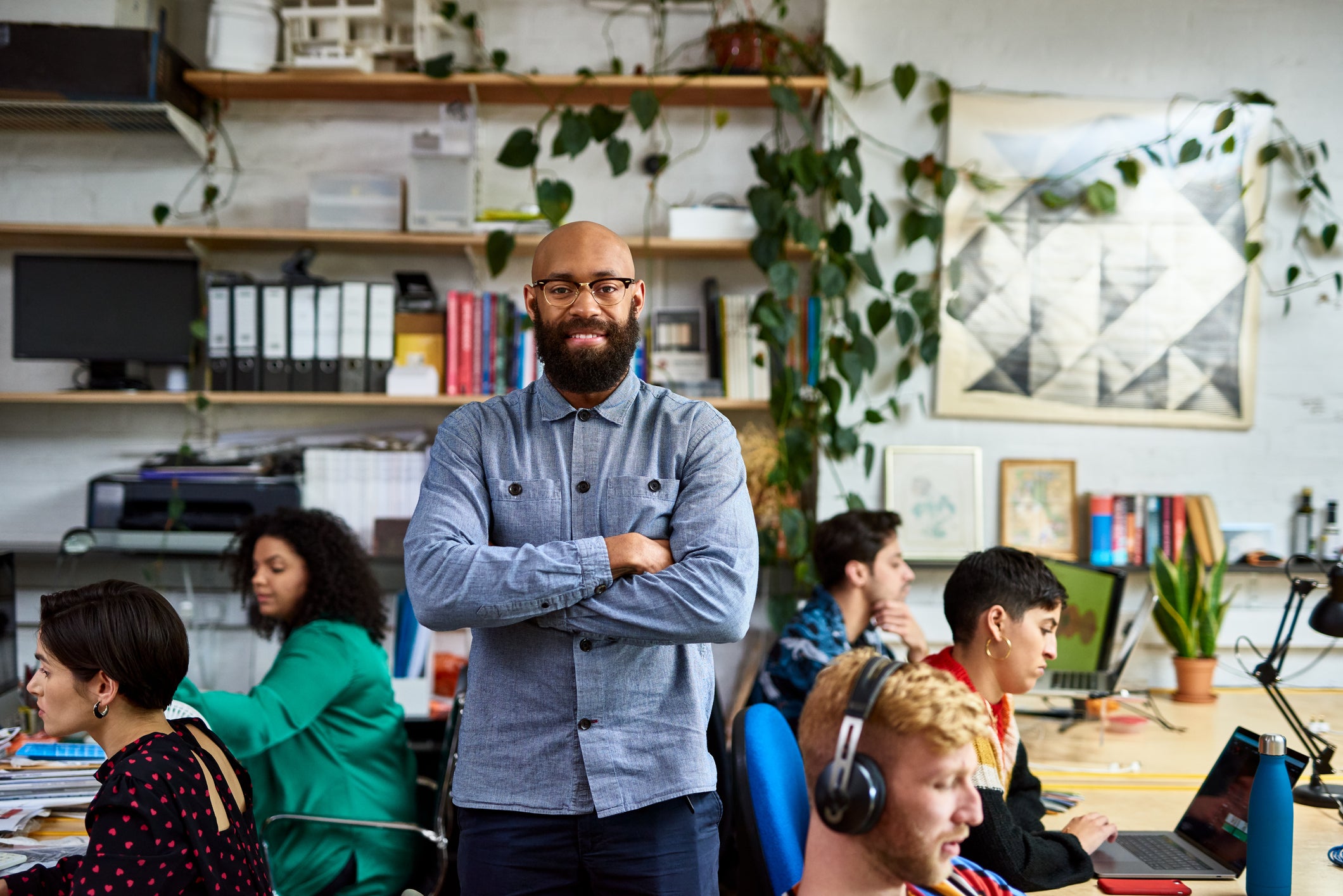 Entrepreneur in busy office smiling at camera
