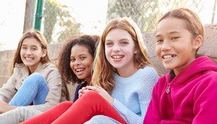 Four Young Girls Hanging Out Together In Park