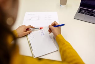 Woman sitting at desk and taking notes at adult education classroom