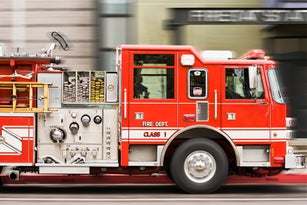 Blurred view of fire truck driving in city