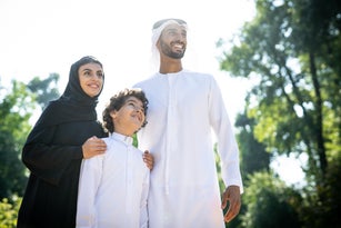 Portrait Of Happy Friends Standing Against Trees