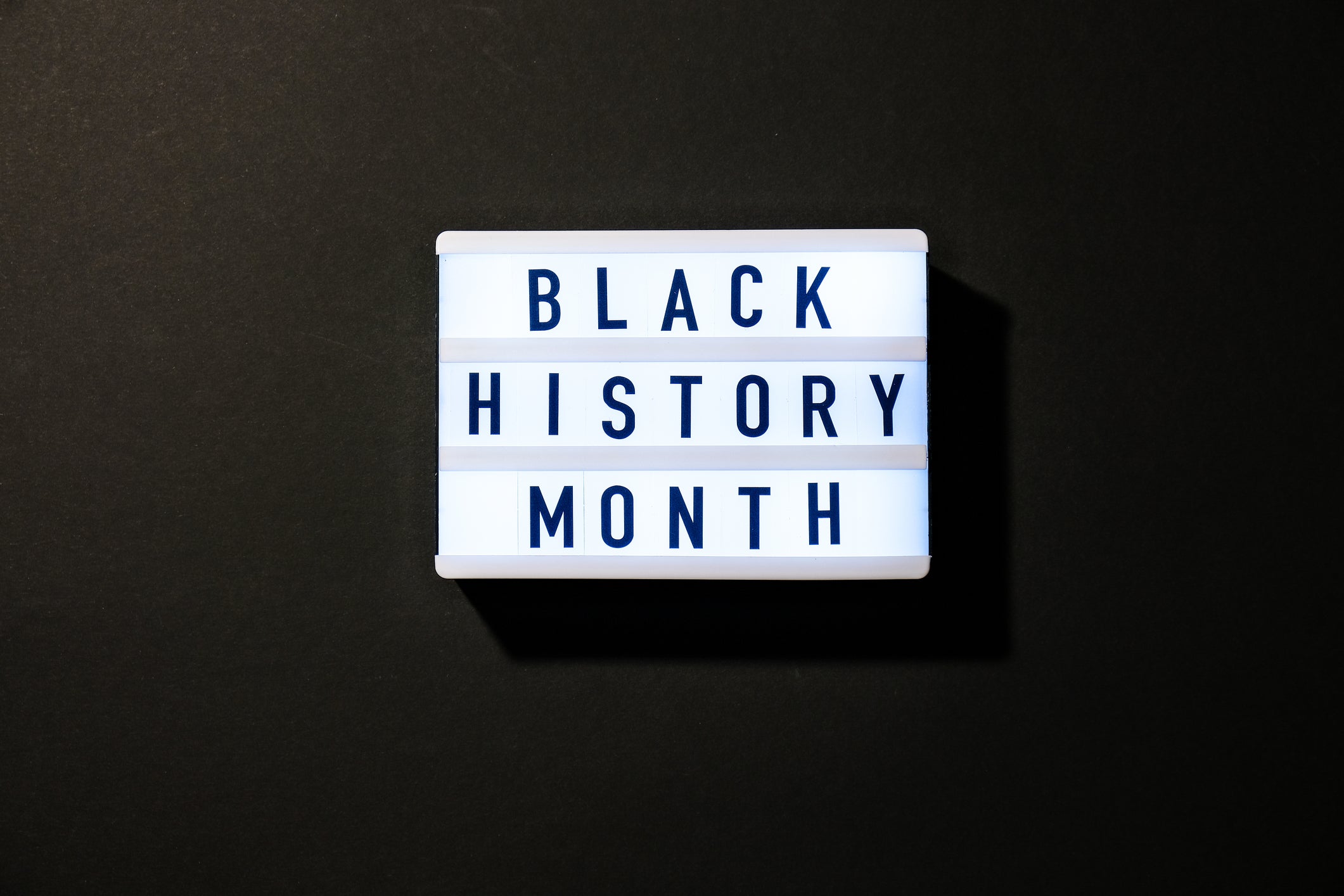 Lightbox with text BLACK HISTORY MONTH on dark black background. Message historical event