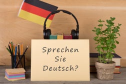 paper with text "sprechen sie deutsch?", flag of the Germany