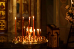 Orthodox Church candles with icons, the Bible and the cross