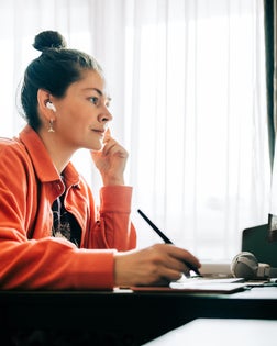 Focused graphic designer working from home office using graphics tablet