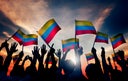 Group of People Waving Columbian Flags in Back Lit