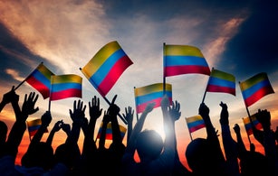 Group of People Waving Columbian Flags in Back Lit