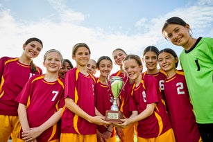 Happy soccer team showing trophy