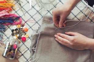 High angle view of woman stitching fabric on table at home