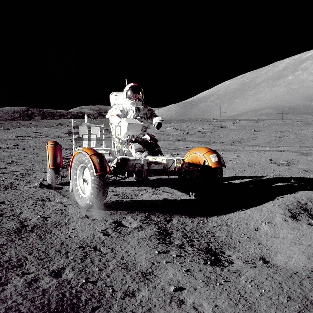 A U.S. astronaut driving a lunar vehicle on the surface of the Moon.
