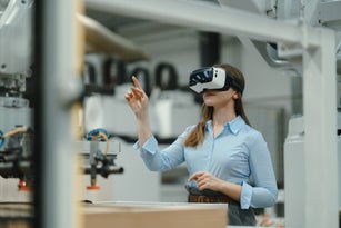Female engineer using VR, in modern industrial factory. Virtual reality and technology in manufacturing industry, Smart glasses guiding manager through process and planing.