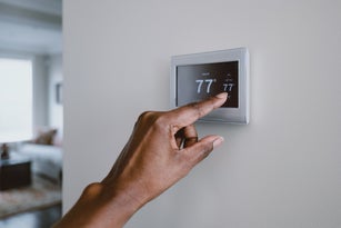Woman Adjusts Thermostat