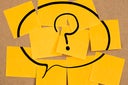 speech bubble with question mark on sticky notes on a board