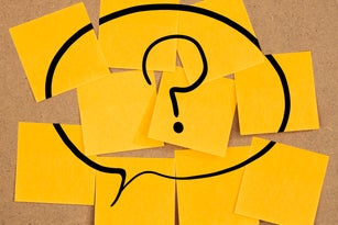 speech bubble with question mark on sticky notes on a board