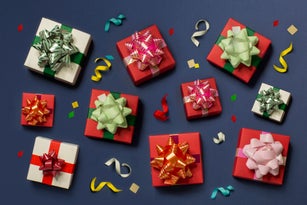 Flat lay gift boxes on confetti dark blue background.
