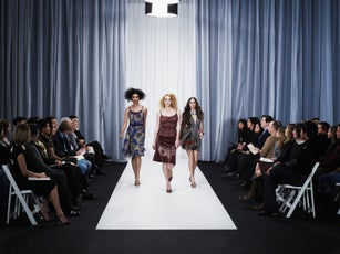 Three female models walking down runway