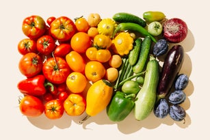 Variety fresh of organic fruits and vegetables rainbow colors on beige background. Healthy food, clean eating, diet and detox concept. Flat lay, top view