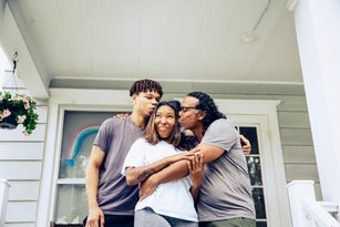 Portrait of father and adult offspring on front porch