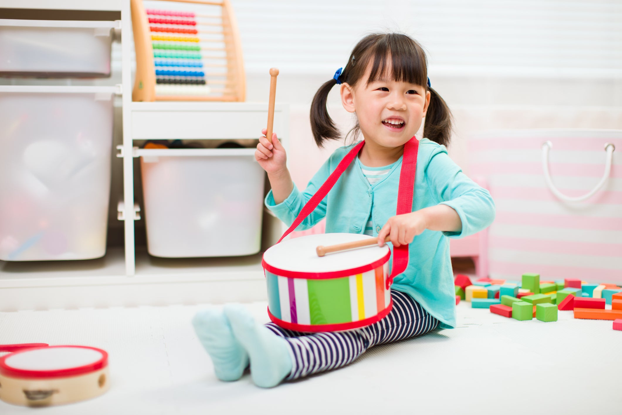 toddler girl play drum at home for homeschooling