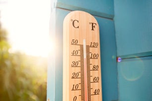 Thermometer at blue wooden wall in garden
