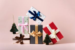 Festive christmas new year background colorful gift boxes and holiday decorations on pink background. New Year's present and Christmas present top view