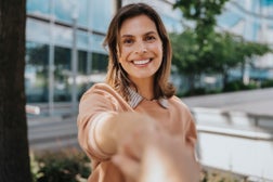 Happy woman shaking hands at office park