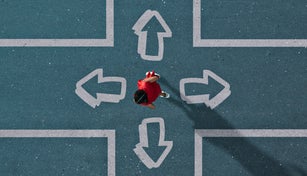 Girl dressed in red choosing direction at painted crossroad