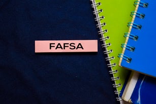 Free Application For Federal Student Aid (FAFSA) on sticky Notes isolated on office desk