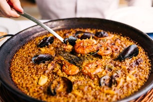 Man eating paella with seafood at the restaurant