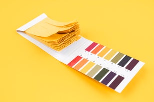 PH test paper pack on yellow background, Universal indicator papers for acidic and alkaline testing. Litmus paper testing kit.
