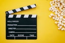 Popcorn and Clapboard On Yellow Background