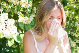 Woman blowing nose on tissue