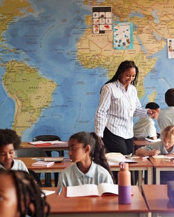 Teacher assisting group of students in classroom