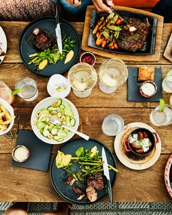 Medium overhead shot of families sharing dinner at outdoor restaurant