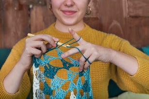 Young woman chrocheting doily, close-up