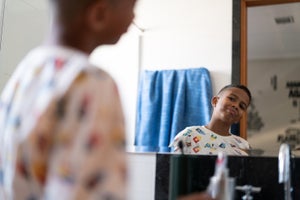 Boy looking at himself in the mirror.