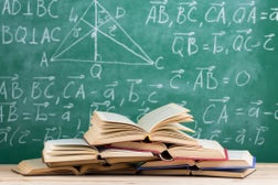 Education concept - books on the desk in the auditorium