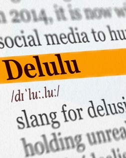 Delulu word highlighted in dictionary with marker, slang for delusional unrealistic beliefs, language trends and pop culture concept