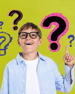Happy curious boy pointing up with colorful question marks aroun