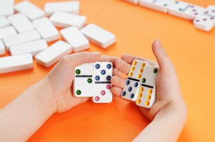 Domino game. Dominoes in children's hands.