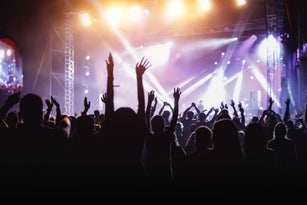 Rock concert, cheering crowd in front of bright colorful stage lights